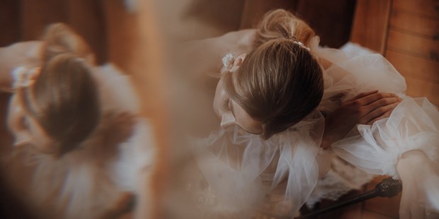Hochzeitsfotos - Berufsfotograf - Groß Plasten - Diebraut steht in einem Chateau in Frankreich auf einer alten Holztreppe und lässt sich, kurz bevor die Trauung stattfindet, fotografieren.  - Lensofbeauty
