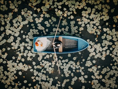 Hochzeitsfotos - Berlin - Paarshooting auf einem Boot mitten in einem Seerosenfeld. Das Aftershooting mit dem Brautpaar wurde mit einer Drohne aus der Luft aufgenommen. - Fotograf David Kohlruss