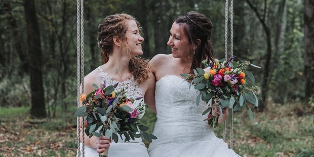 Hochzeitsfotos - Art des Shootings: Fotostory - Innsbruck - Brautpaar sitzt auf einer Schaukel und lacht.  - Sophia Eerden