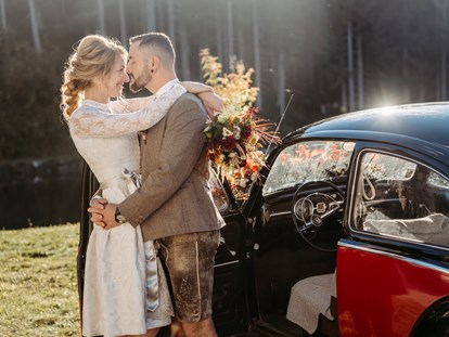 Hochzeitsfotos - Videografie buchbar - Aistersheim - Brautpaar vor einem schwarzen Oldtimer - Facetten Fotografie